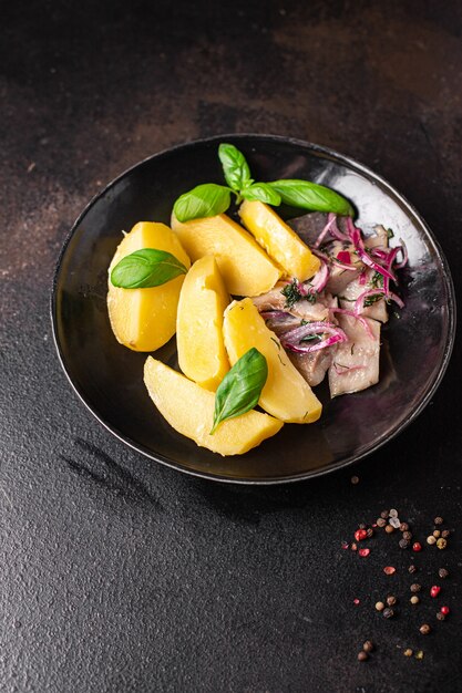 Hareng et pommes de terre deuxième plat poisson mariné oignon frais prêt à manger repas collation sur la table