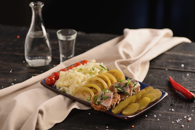 Hareng salé avec des légumes marinés. sur une table en bois