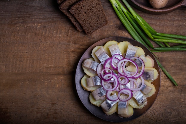 Photo hareng salé avec pommes de terre bouillies et oignons