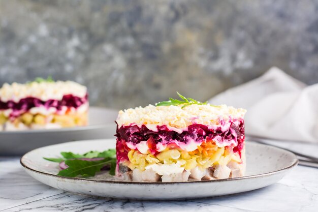 Hareng sous un manteau de fourrure Salade de Noël traditionnelle sur une assiette sur la table