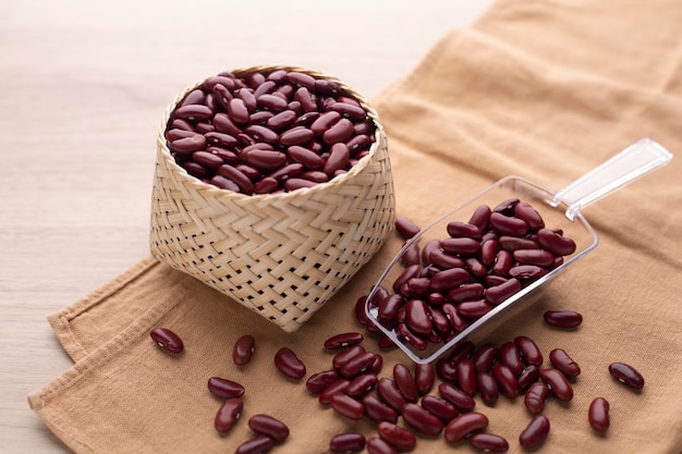 Photo haricot rouge biologique dans un panier sur une table en bois et une cuillère en plastique ingrédient nutritionnel protéique pour