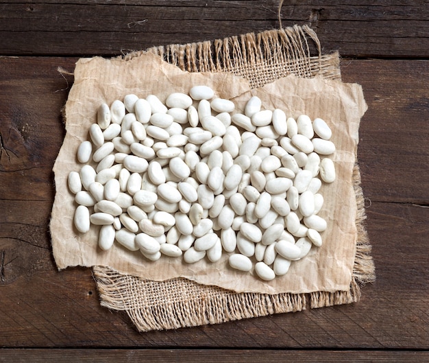 Haricots blancs sur la vue de dessus de table en bois marron