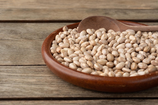 Haricots bruns dans une assiette sur table en bois courte profondeur de champ