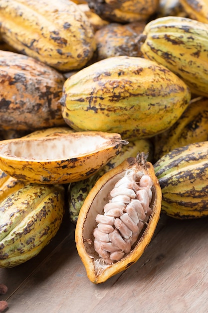 Photo haricots crus de cacao et gousse de cacao sur une surface en bois