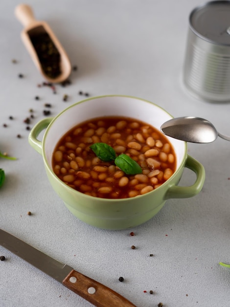 Photo haricots cuits au four à la sauce tomate dans une assiette sur un fond gris