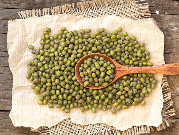 Haricots mungo secs crus et une vue de dessus de cuillère sur bois