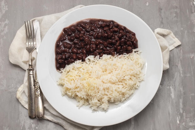 Haricots noirs et riz bouilli sur plat blanc