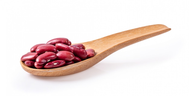 Haricots rouges en cuillère de bois isolé sur fond blanc