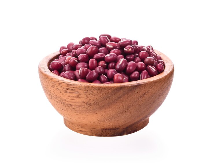 Haricots rouges dans un bol en bois sur fond blanc