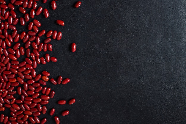 Haricots rouges sur fond noir. copier l'espace. vue de dessus.