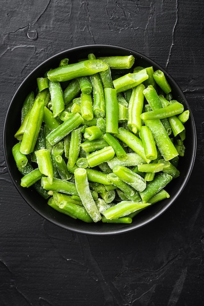 Haricots verts bio surgelés. Ensemble de concept d'alimentation saine, dans un bol, sur pierre noire