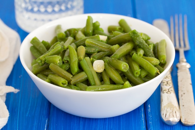 Haricots verts bouillis à l'ail dans un bol blanc