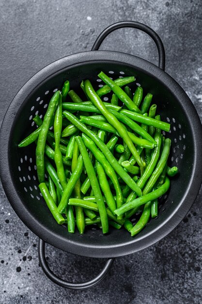 Haricots verts crus dans une passoire