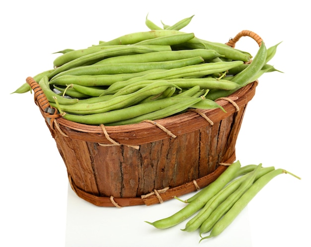 Haricots verts dans un panier en bois isolé sur blanc