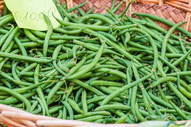 Photo des haricots verts dans un panier dans un marché alimentaire de rue avec un prix rapproché