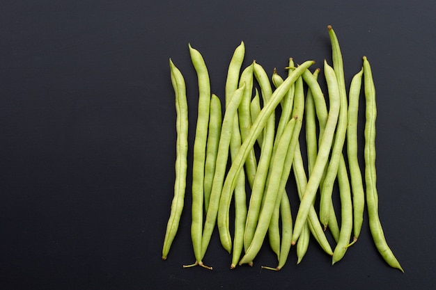 Haricots verts sur mur sombre. Copier l'espace