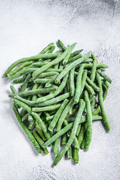 Photo haricots verts surgelés sur la table de cuisine blanche. fond blanc. vue de dessus.