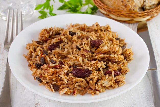 Haricots avec viande et riz dans l&#39;assiette et fourchette avec couteau