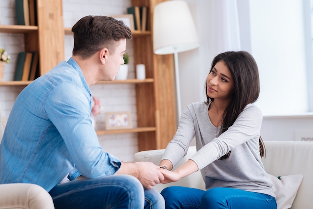 Harmony à nouveau. Couple doux inexpérimenté se tenant la main tout en se regardant