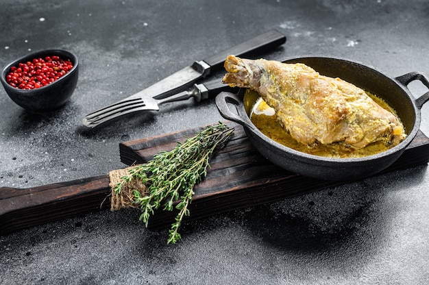 Haunches de lièvre cuit au four dans la casserole avec des légumes cuits.