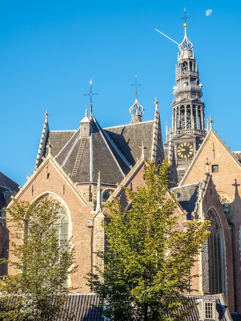 Haut de l'ancienne église (Oude Kerk) dans le principal quartier rouge d'Amsterdam, Pays-Bas, sous ciel bleu