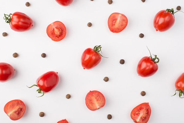 Haut au-dessus de la vue aérienne photo de tomates cerises et de grains de poivre isolés sur fond blanc