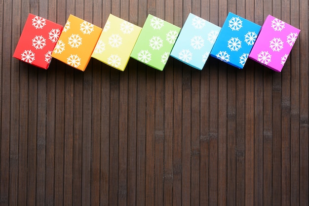 D'en Haut Des Cadeaux Colorés De Noël Dans Une Rangée Sur Une Table En Bois.