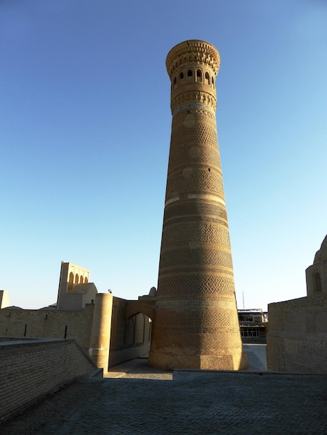 Haut minaret en brique dans la ville de Boukhara