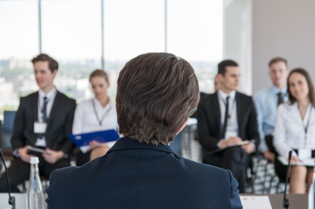 Haut-parleur arrière et hommes d'affaires écoutant attentivement à la conférence