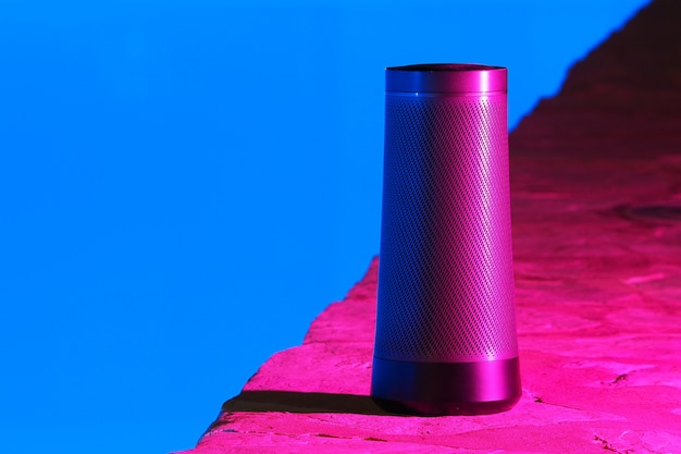 Haut-parleur moderne portable avec assistant vocal la nuit près de la piscine