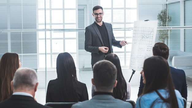 Le haut-parleur pointe vers un tableau à feuilles mobiles pendant la présentation de l'entreprise