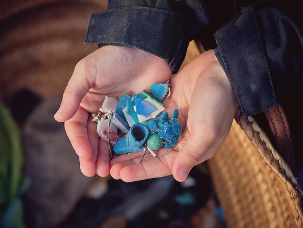 D'en haut, un préadolescent anonyme avec des déchets plastiques ramassés lors d'une action de bénévolat