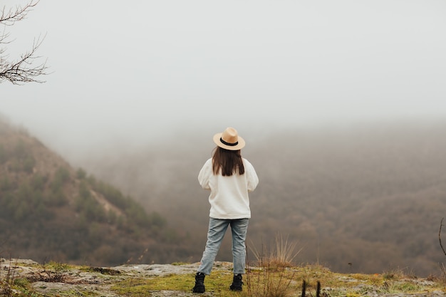 Haut de la vallée de la montagne avec du brouillard en hiver. La fille se détend dans la montagne le matin brumeux.