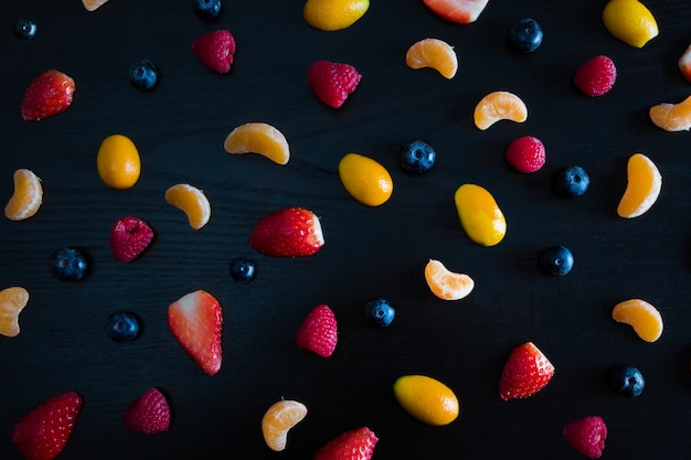 Haut de la vue de mandarine colorée, framboise, myrtille et fraises.