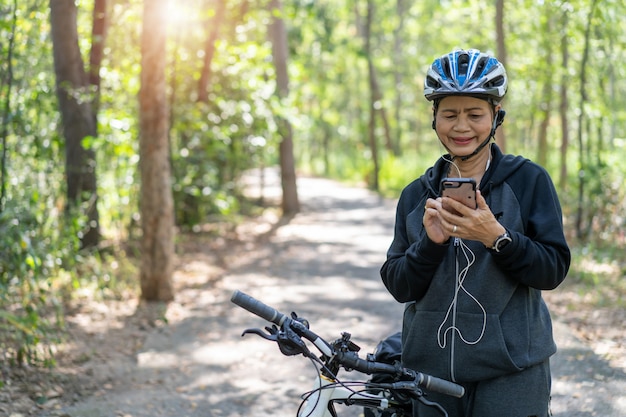 Haute femme asiatique à vélo dans le parc