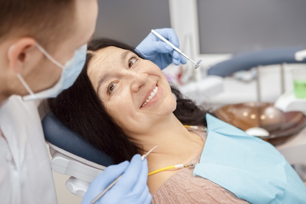 Haute femme visitant un dentiste à la clinique dentaire