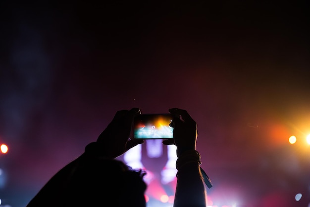 Haute section d'un homme photographiant un concert la nuit