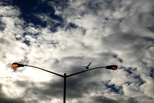 Photo haute section de lumière de rue contre un ciel nuageux