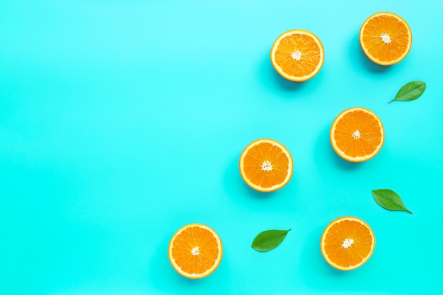 Haute vitamine C, juteuse et sucrée. Fruits orange frais sur fond bleu.