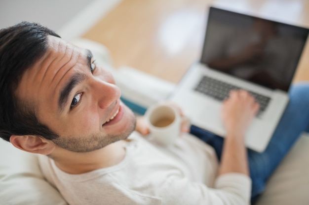 Haute vue angle, de, sourire, jeune homme, utilisation, sien, ordinateur portable