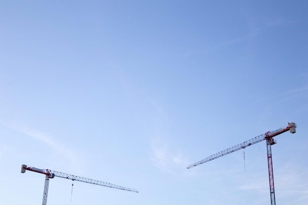 Photo de hautes grues de construction dans le ciel.