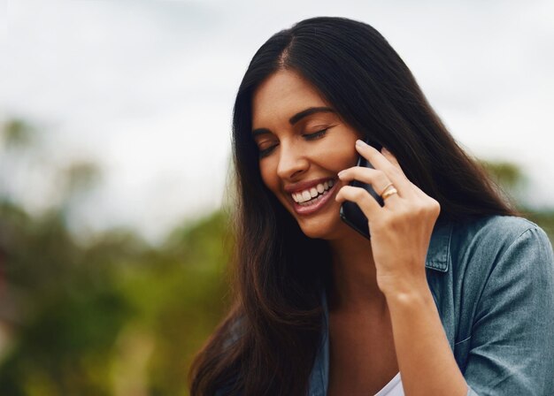 Hé, je suis si heureux que vous ayez appelé Photo d'une jolie jeune femme utilisant un téléphone portable dans un parc