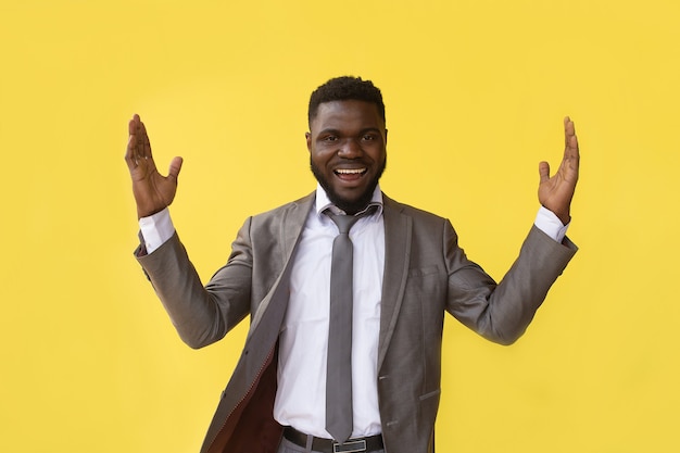 Hé toi. Guy africain positif pointant les doigts à la caméra posant sur fond jaune. Prise de vue en studio