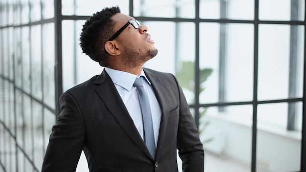 Head shot close up jeune homme d'affaires afro-américain pensif entrepreneur regardant loin