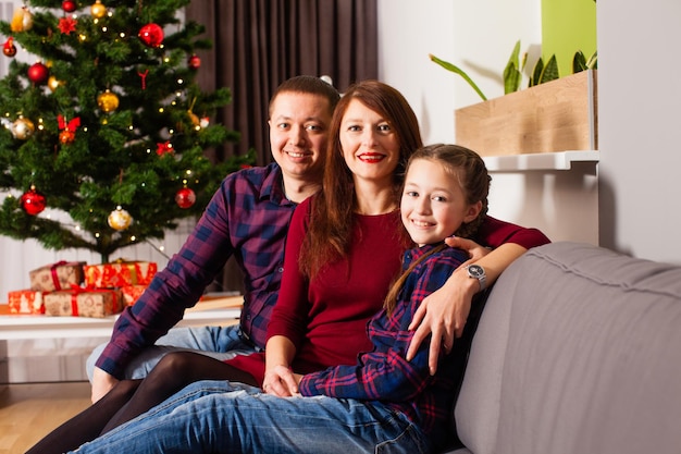 Héhé, assis sur un canapé à la maison près de l'arbre de Noël