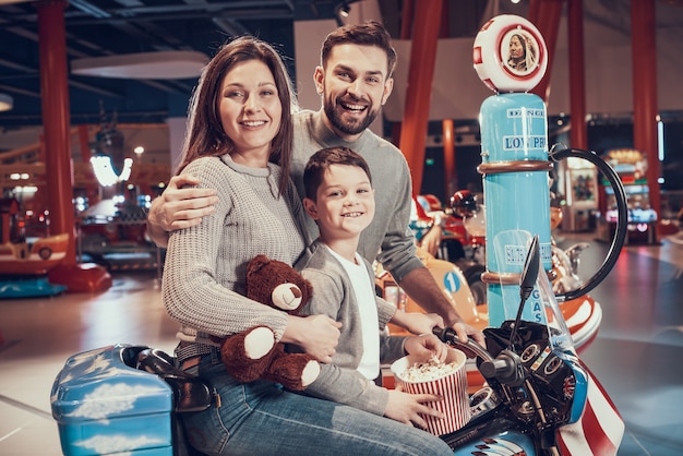 Héhé, assis sur une moto jouet avec pop-corn.