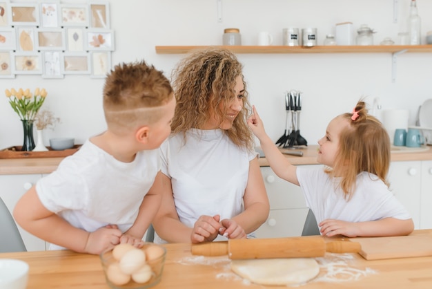 Héhé dans la cuisine. la mère et les enfants préparent la pâte, préparent des biscuits