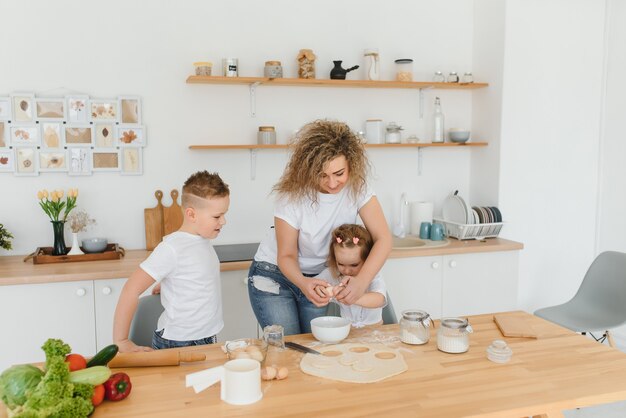 Héhé dans la cuisine. la mère et les enfants préparent la pâte, préparent des biscuits