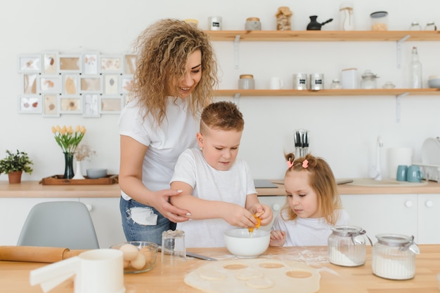 Héhé dans la cuisine. la mère et les enfants préparent la pâte, préparent des biscuits