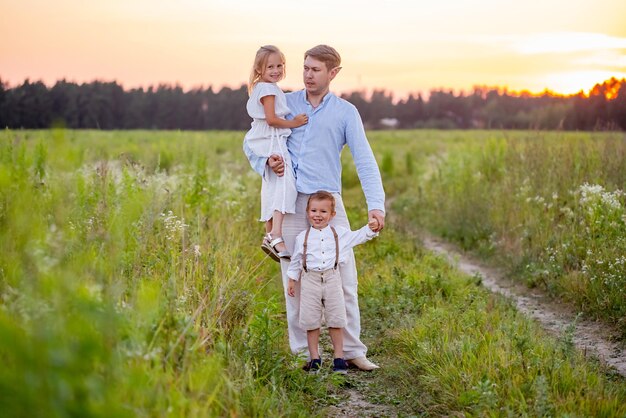 Héhé avec deux enfants sur le terrain au coucher du soleil l'heure d'été.